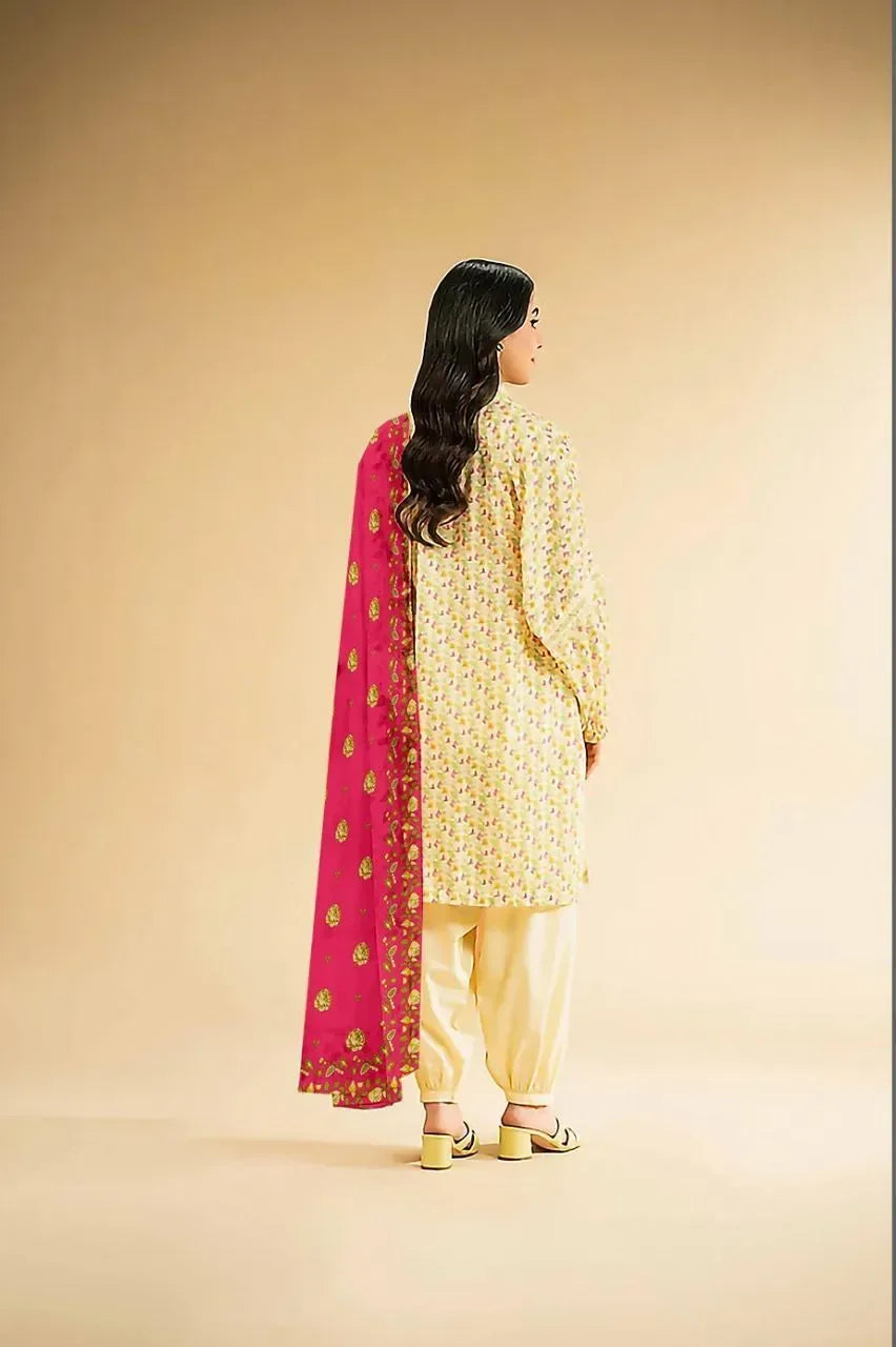 Woman in traditional yellow outfit with pink dupatta on beige background