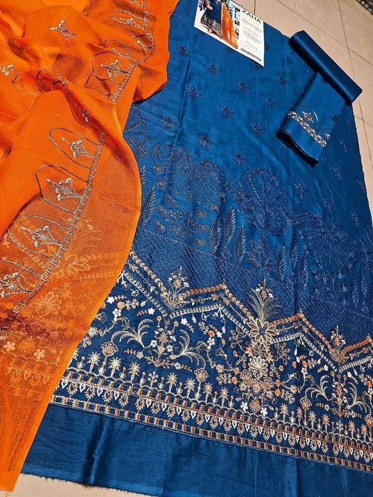 Blue and orange fabric with intricate embroidery on a tiled floor.