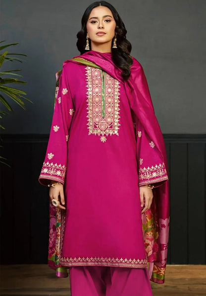 Woman wearing a pink traditional outfit with intricate embroidery against a dark background