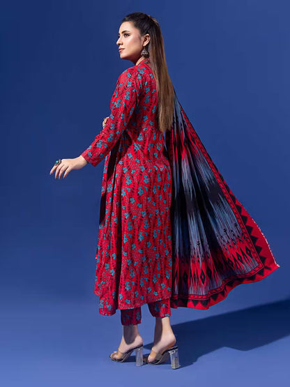 Woman wearing a red floral outfit with a black and red patterned dupatta on a blue background