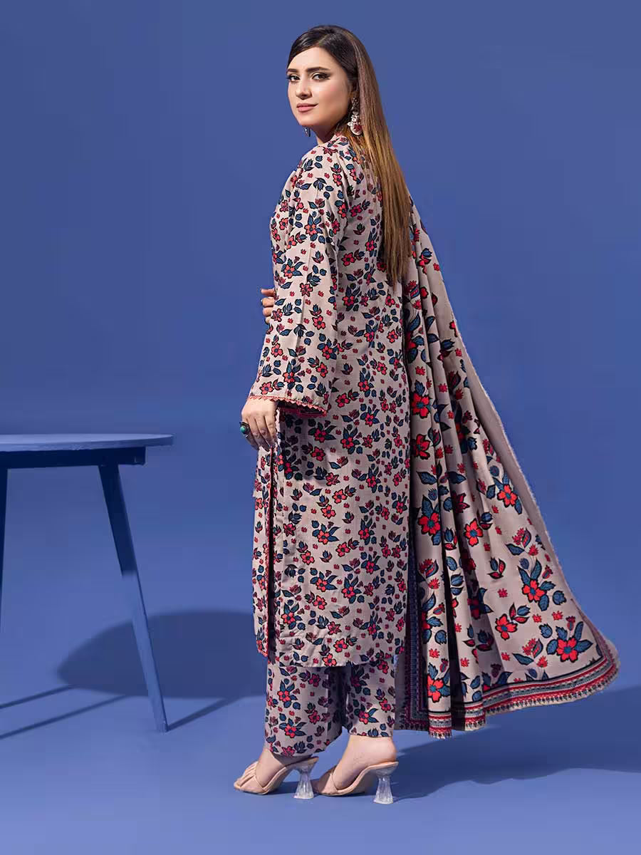 Woman wearing a floral dress with a long scarf against a blue background