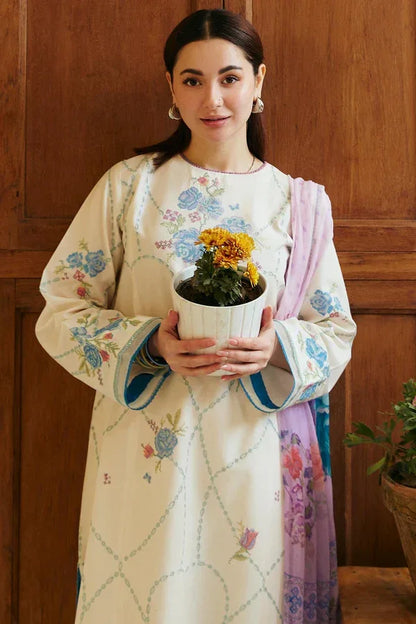 Woman in a traditional outfit holding a potted plant against a wooden background