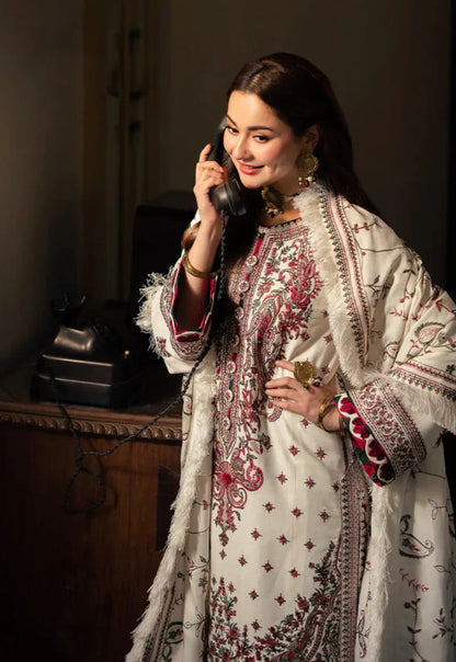 Woman in traditional embroidered outfit using a vintage phone indoors.