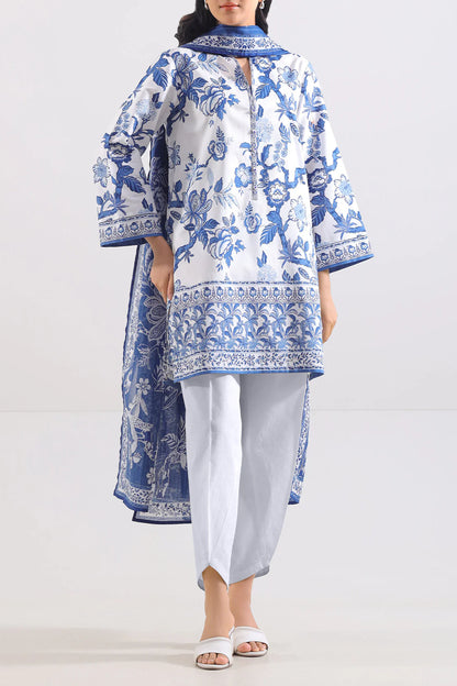 Woman wearing a blue and white floral embroidered outfit on a white background