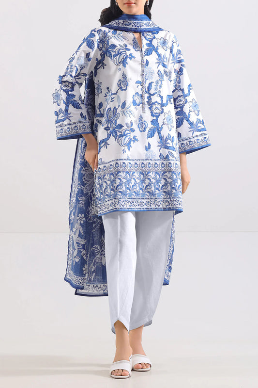 Woman wearing a blue and white floral embroidered outfit on a white background
