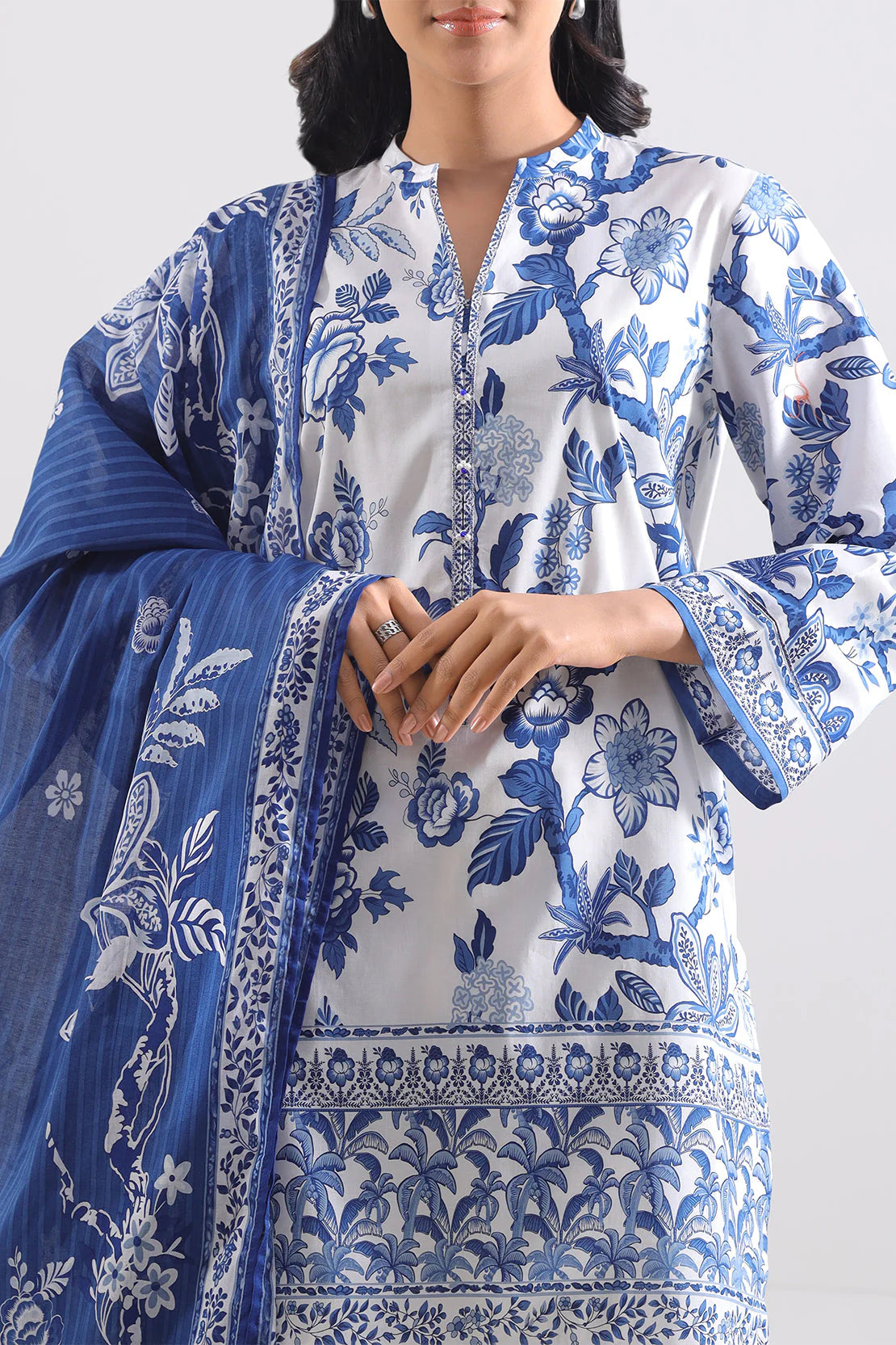 Woman wearing a blue and white floral patterned outfit on a white background