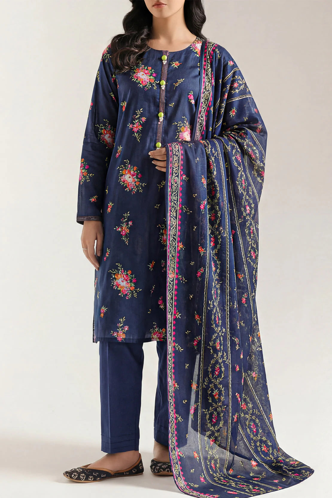 Woman wearing a navy blue floral outfit with a matching dupatta on a white background