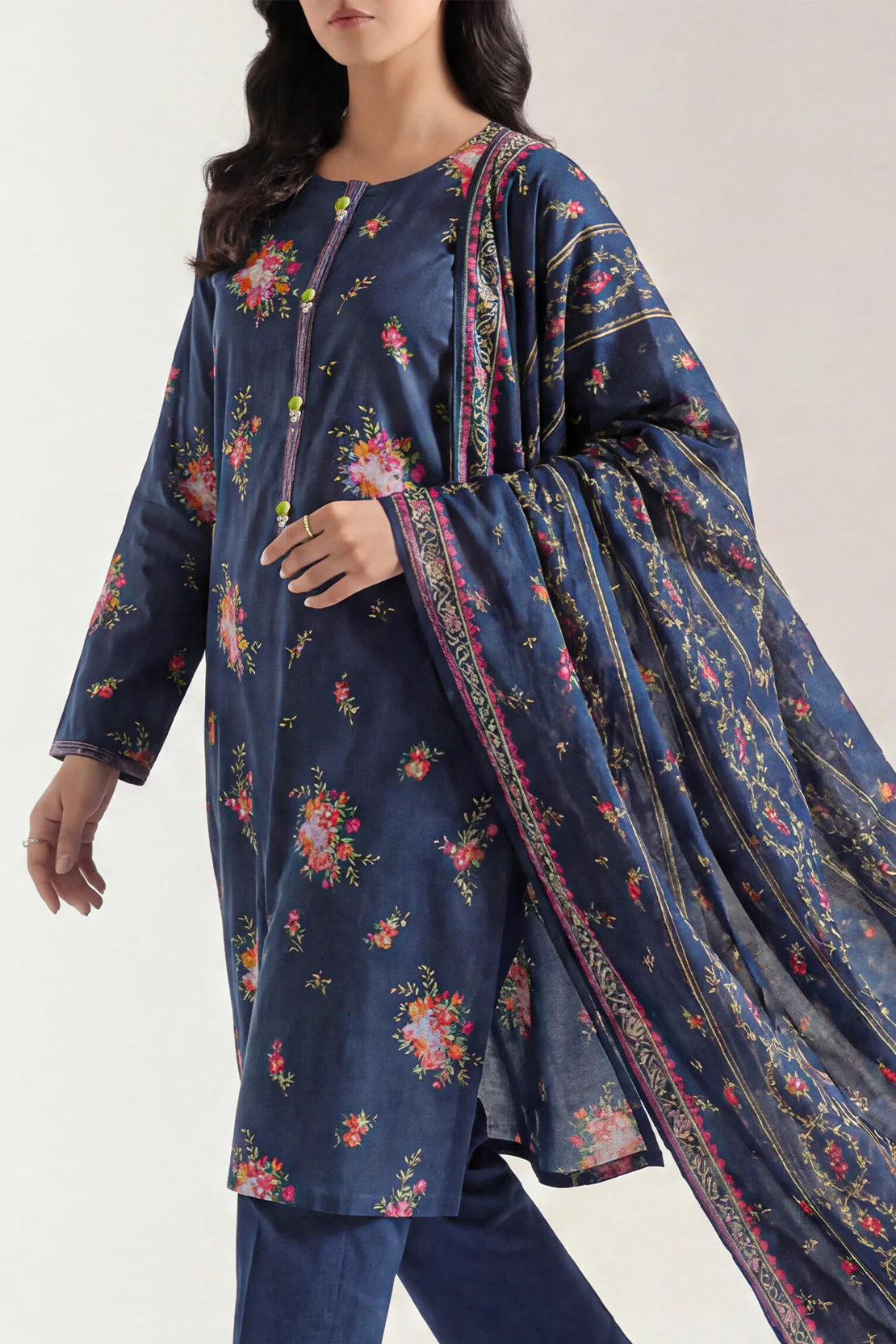Woman wearing a navy blue floral printed outfit with a matching dupatta on a white background