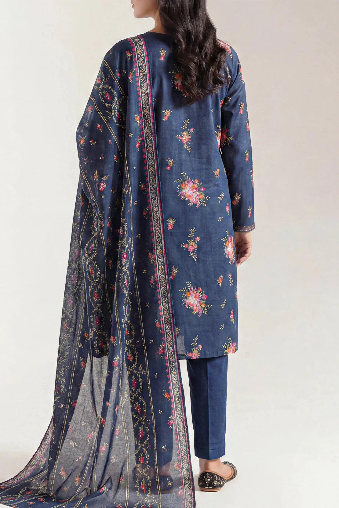 Woman wearing a blue floral embroidered outfit with a matching dupatta on a white background
