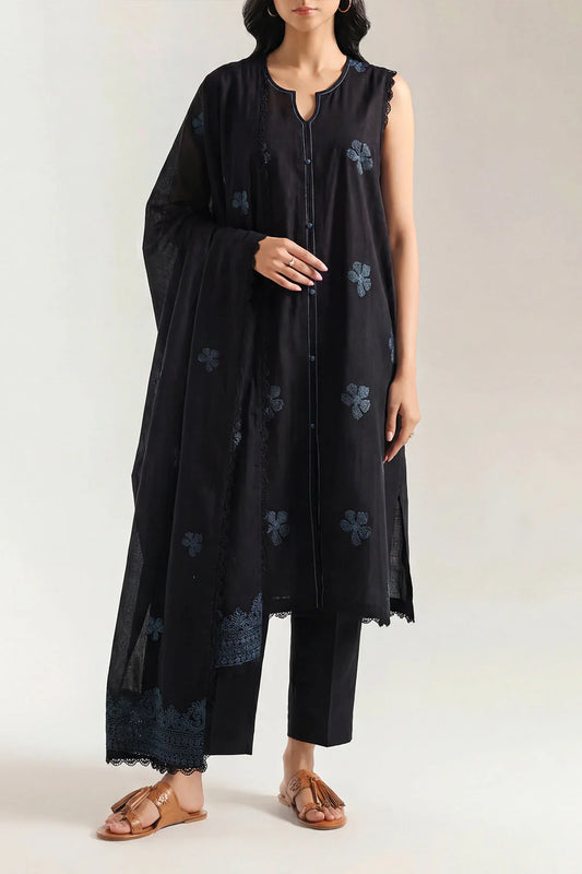 Woman wearing a black dress with floral patterns on a white background