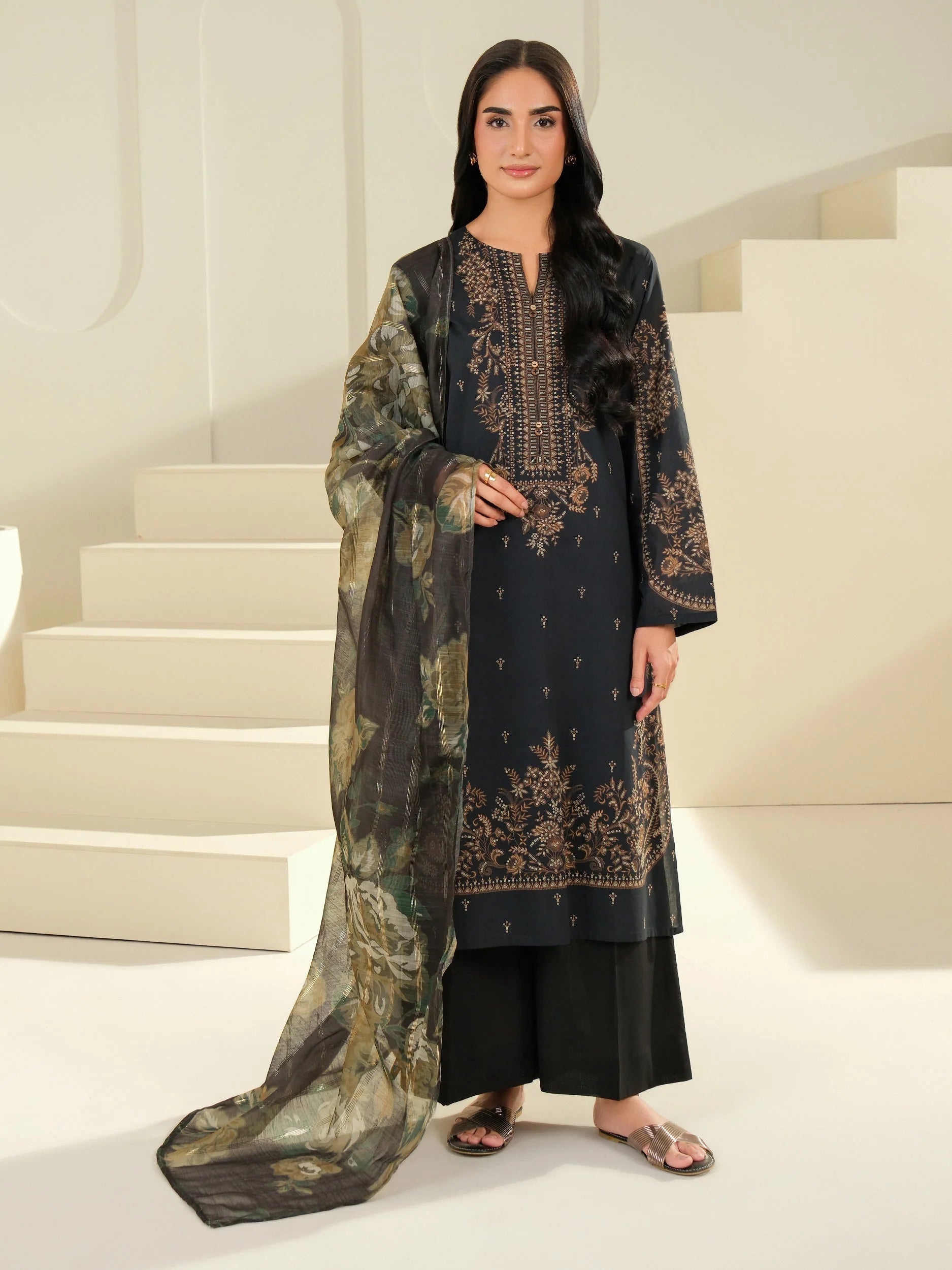 Woman in traditional embroidered outfit standing on a staircase