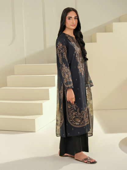 Woman wearing a dark blue embroidered outfit standing on a staircase.