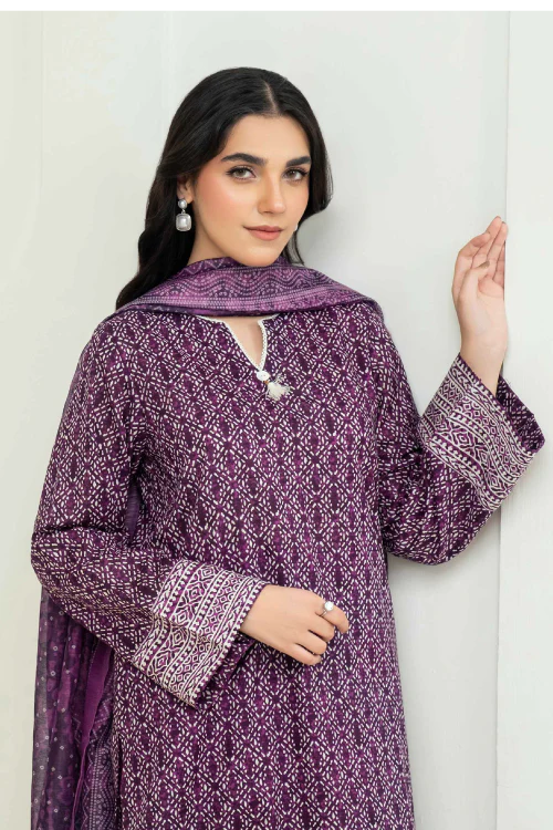 Woman wearing a purple patterned outfit against a white background