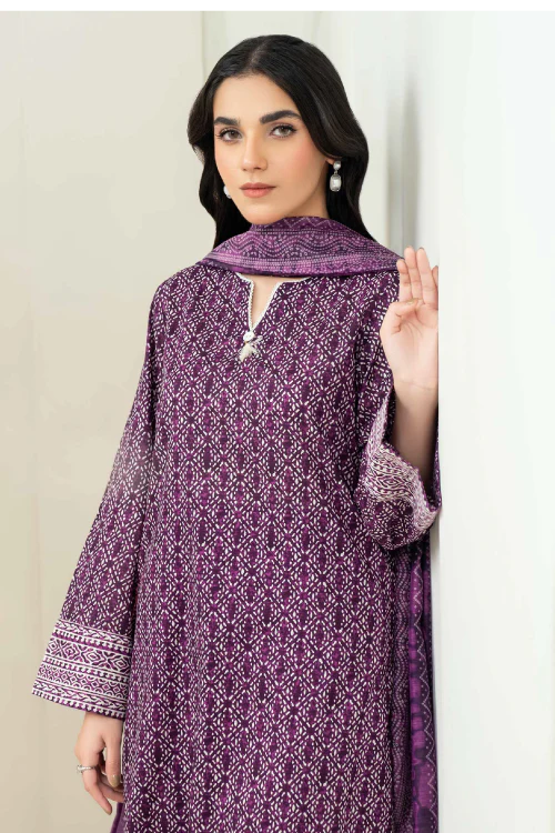 Woman wearing a purple patterned outfit against a white background