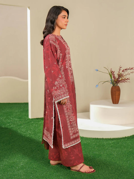 Woman wearing a red embroidered traditional outfit standing on green grass with a neutral background.