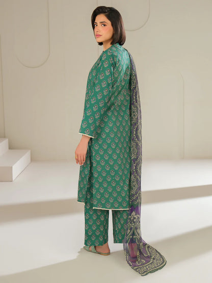 Woman wearing a green traditional outfit with a matching dupatta in a minimalistic setting