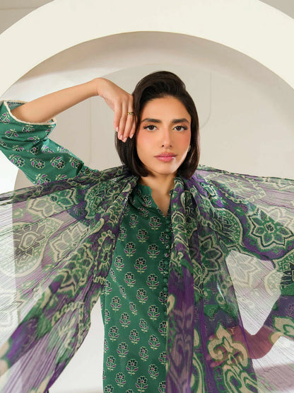 Woman wearing a green and purple patterned scarf with a white background