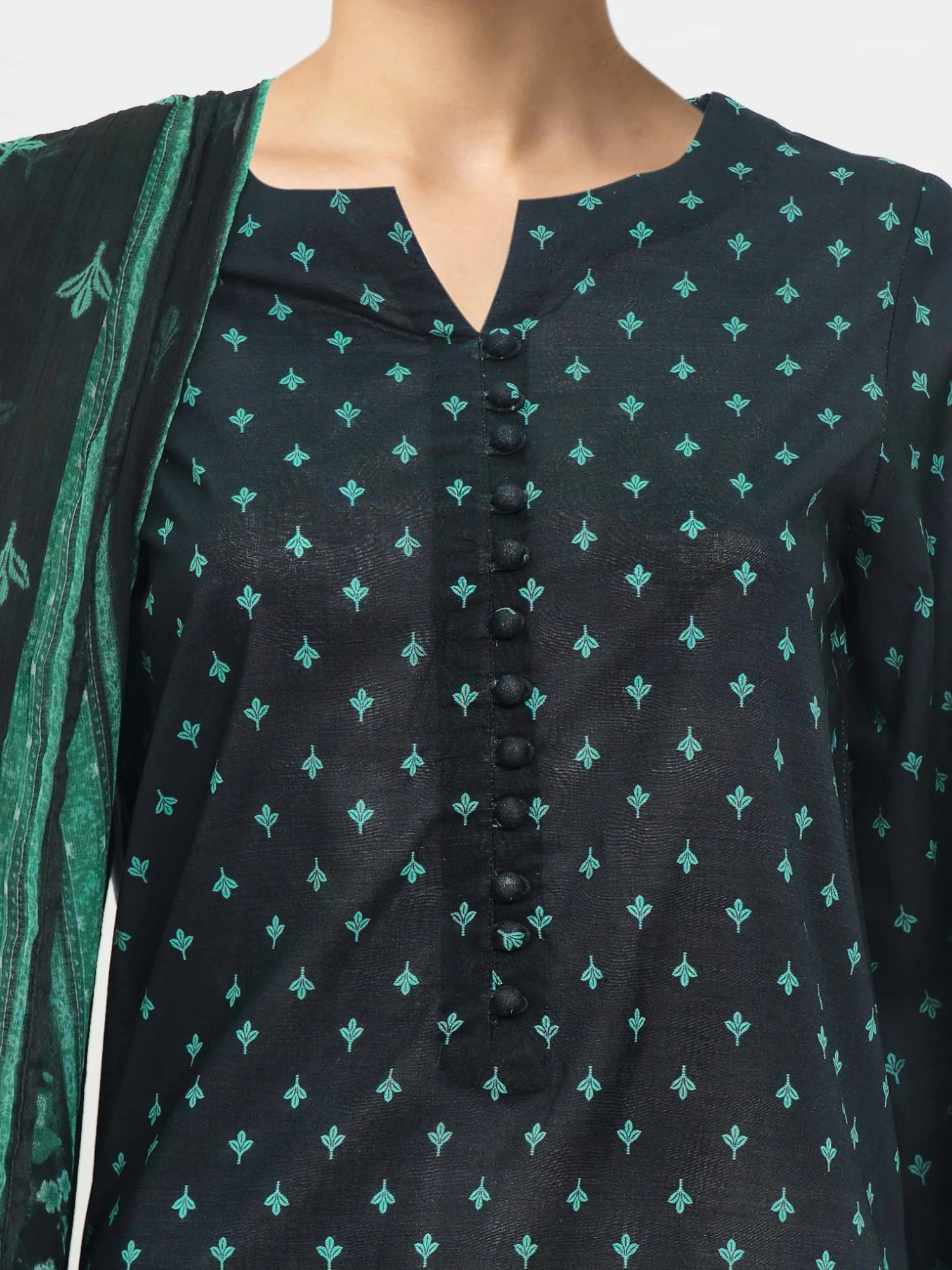 Black patterned shirt with green accents on a neutral background