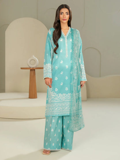 Woman wearing a light blue embroidered traditional outfit in a minimalistic setting
