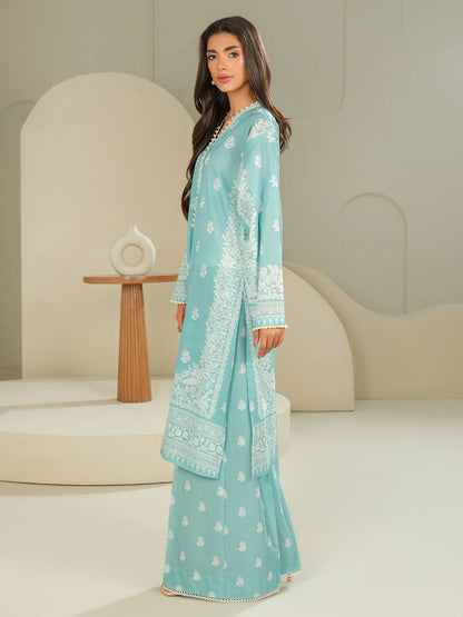 Woman wearing a light blue embroidered traditional outfit in a minimalistic setting