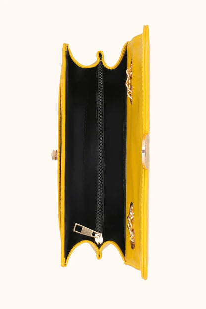 Yellow clutch bag with a gold chain on a white background