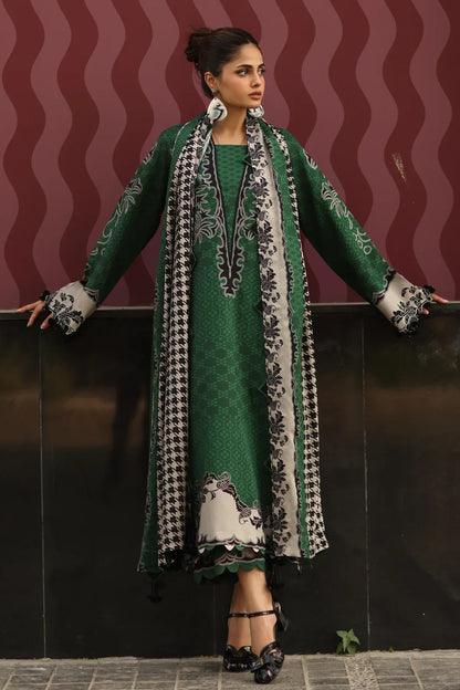 Woman wearing a green traditional outfit with a patterned scarf against a dark background