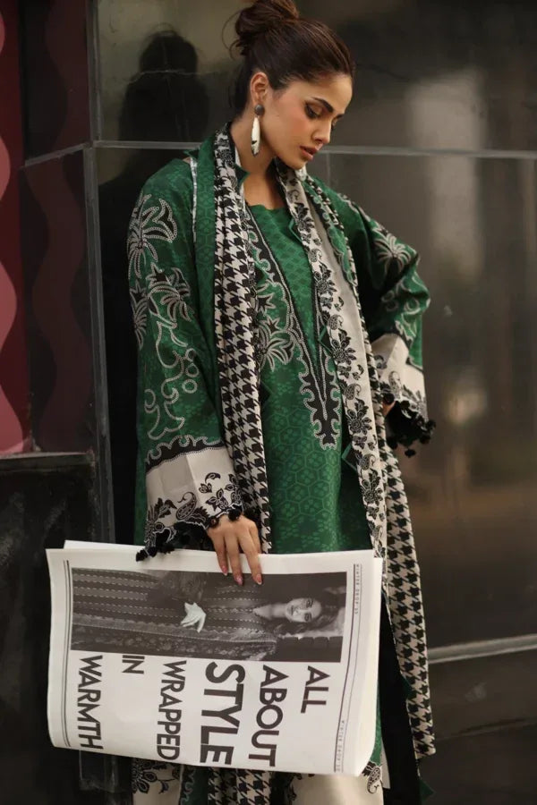 Woman holding a newspaper with a fashion theme, wearing a green dress and patterned coat.