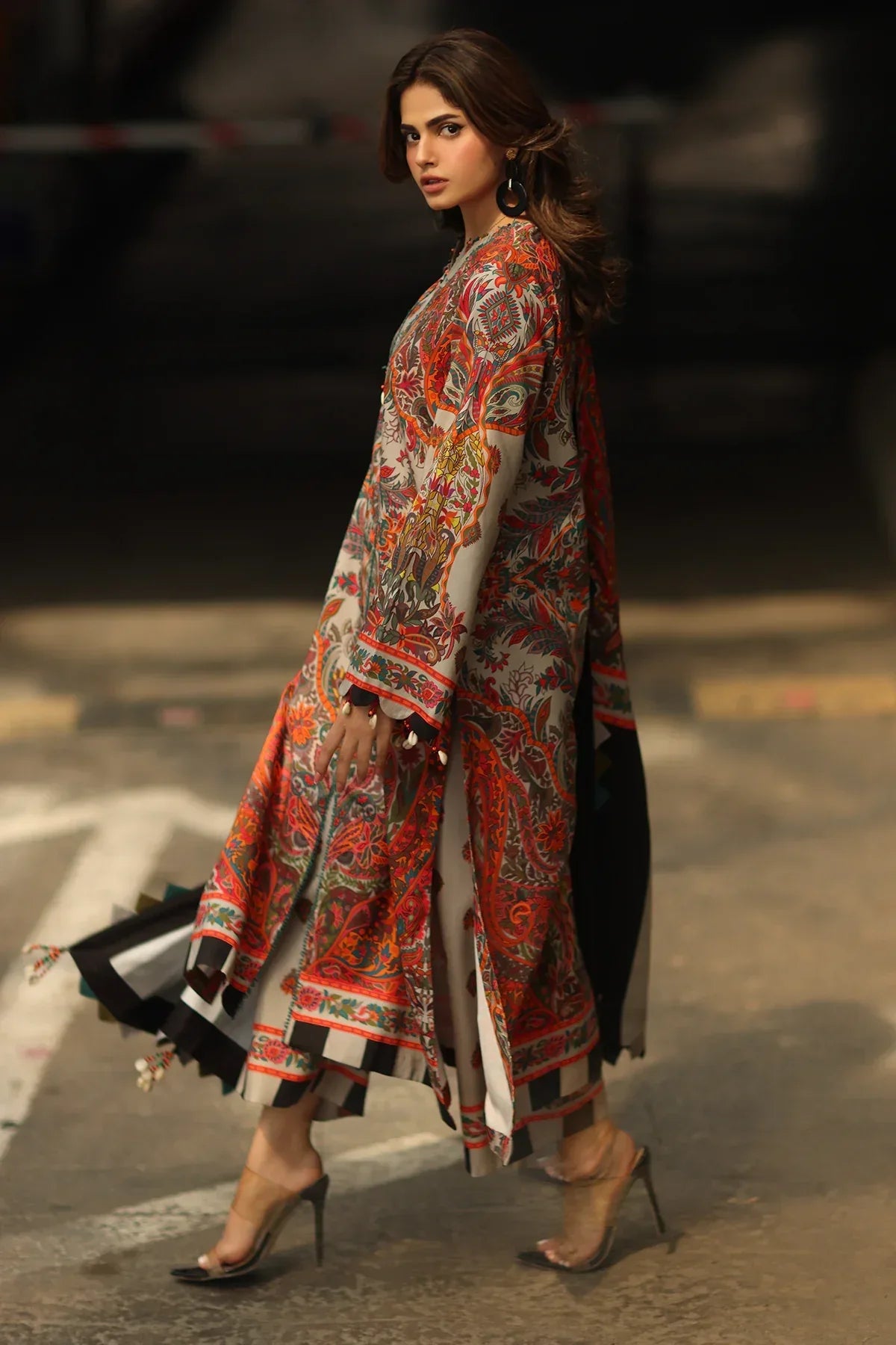 Woman wearing a colorful traditional outfit on a blurred street background