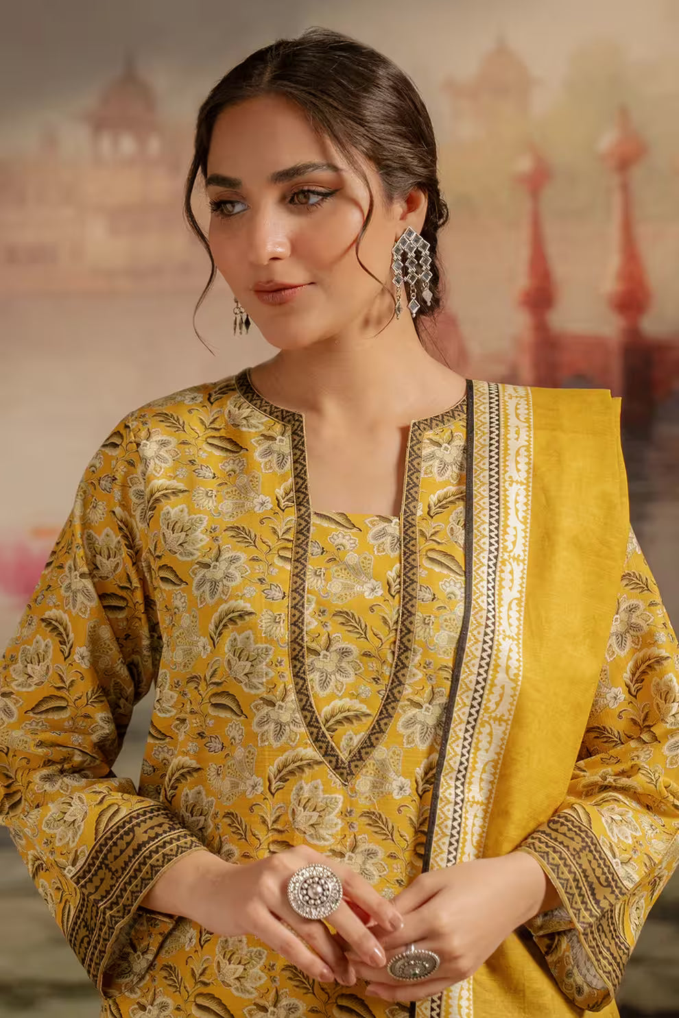 Woman wearing a yellow and gold traditional outfit with intricate patterns.