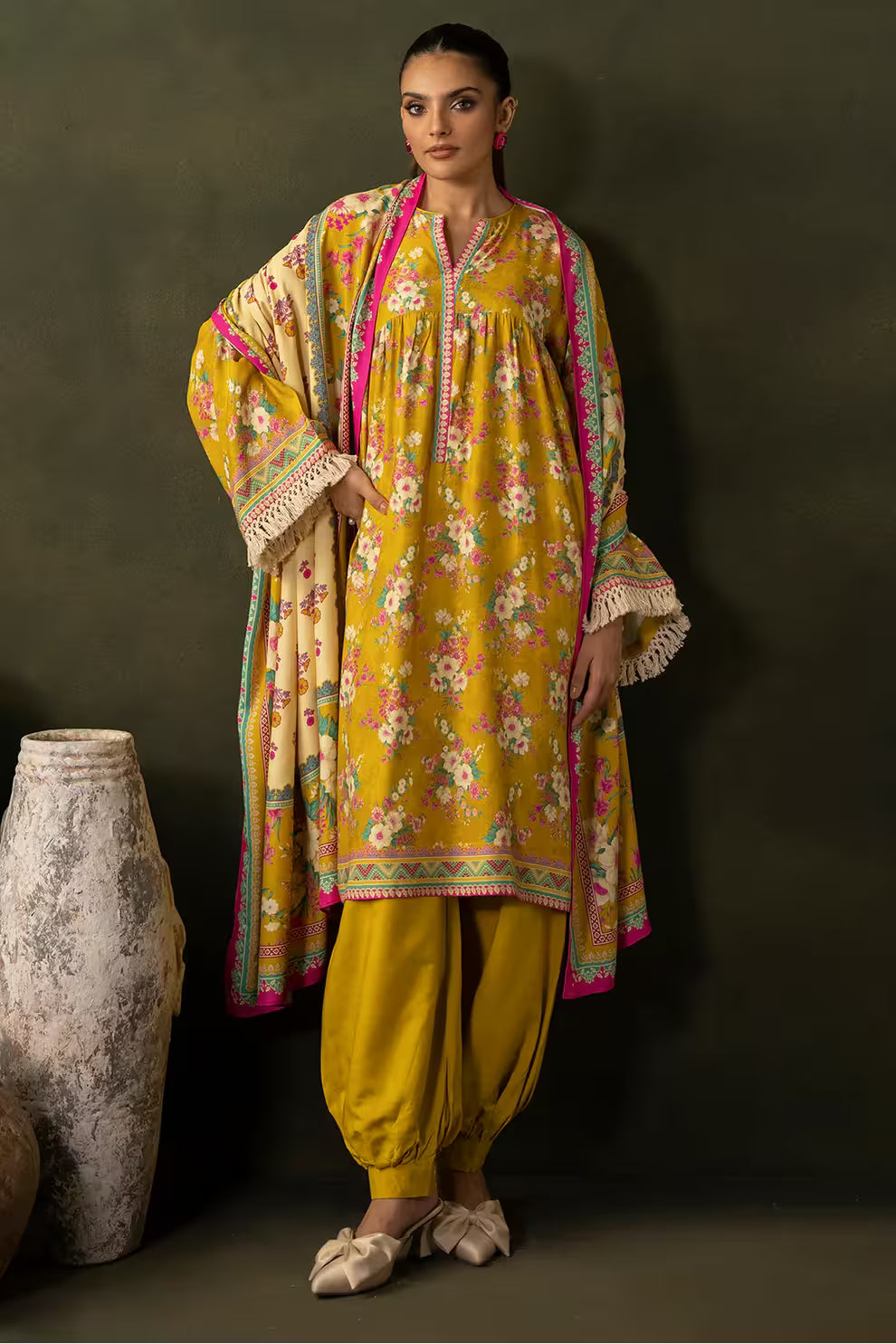 Woman wearing a yellow floral traditional outfit with a dark background