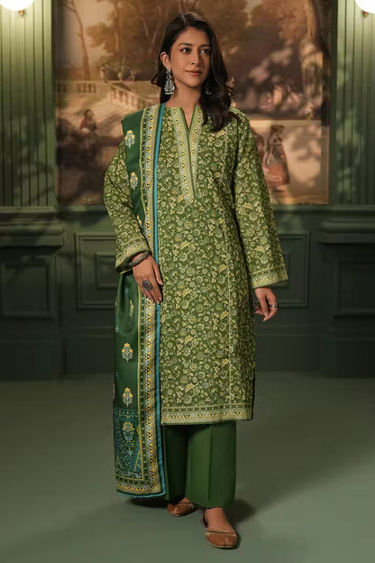 Woman wearing a green traditional outfit with a matching dupatta in a decorated room.