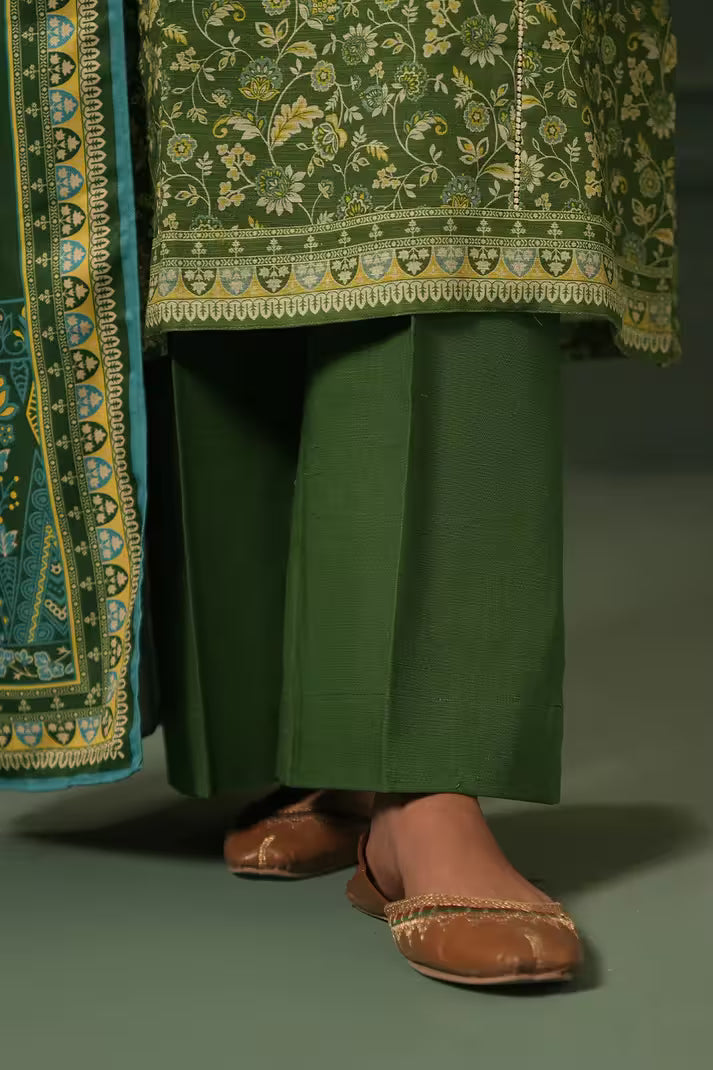 Green traditional outfit with floral patterns and brown shoes on a dark background