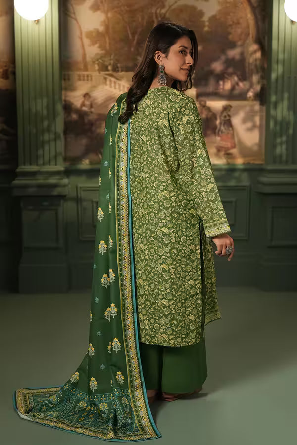 Woman wearing a green floral traditional outfit with a matching dupatta in an indoor setting.