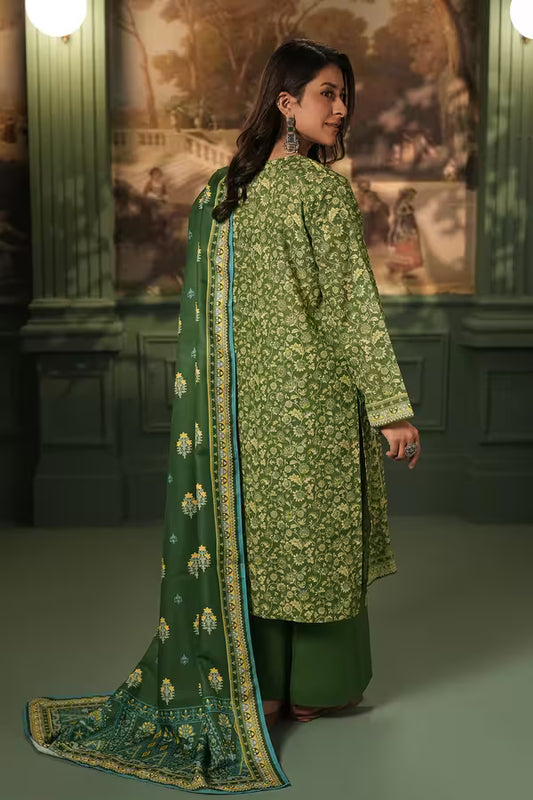 Woman wearing a green floral traditional outfit with a matching dupatta in an indoor setting.