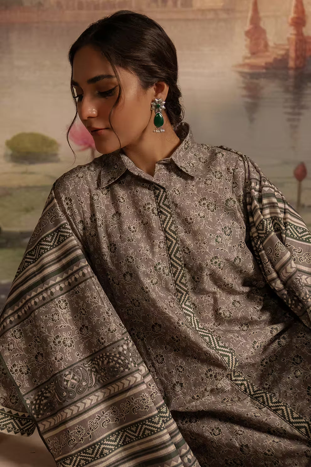 Woman wearing a patterned traditional outfit with a scenic background