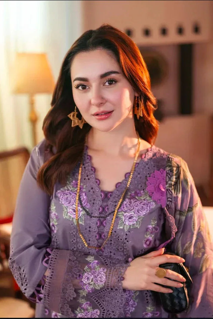Woman wearing a purple embroidered outfit in an indoor setting