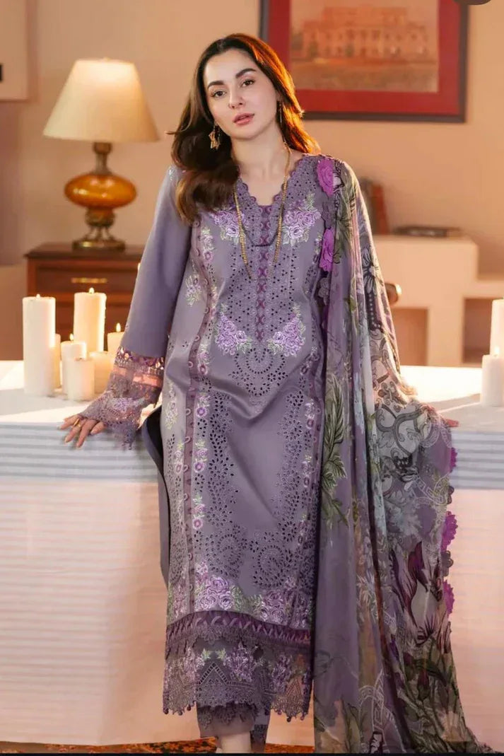 Woman in a purple embroidered outfit standing in a decorated room with candles and a lamp.