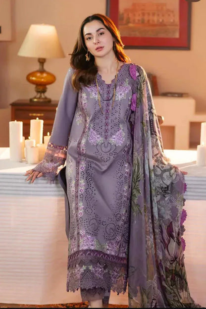 Woman in a purple embroidered outfit standing in a decorated room with candles and a lamp.