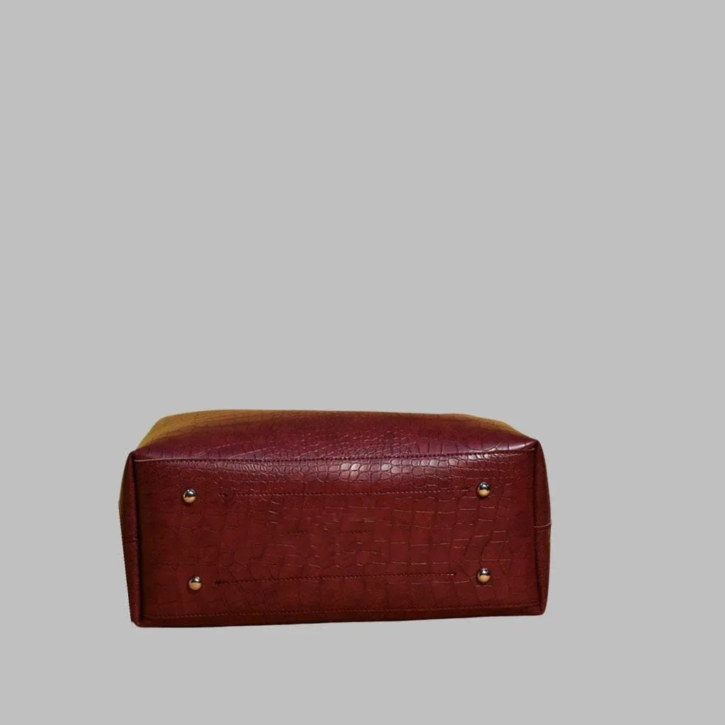 Red leather bag with gold studs on a gray background