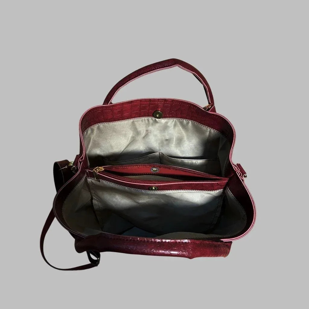 Red handbag with silver interior on a gray background