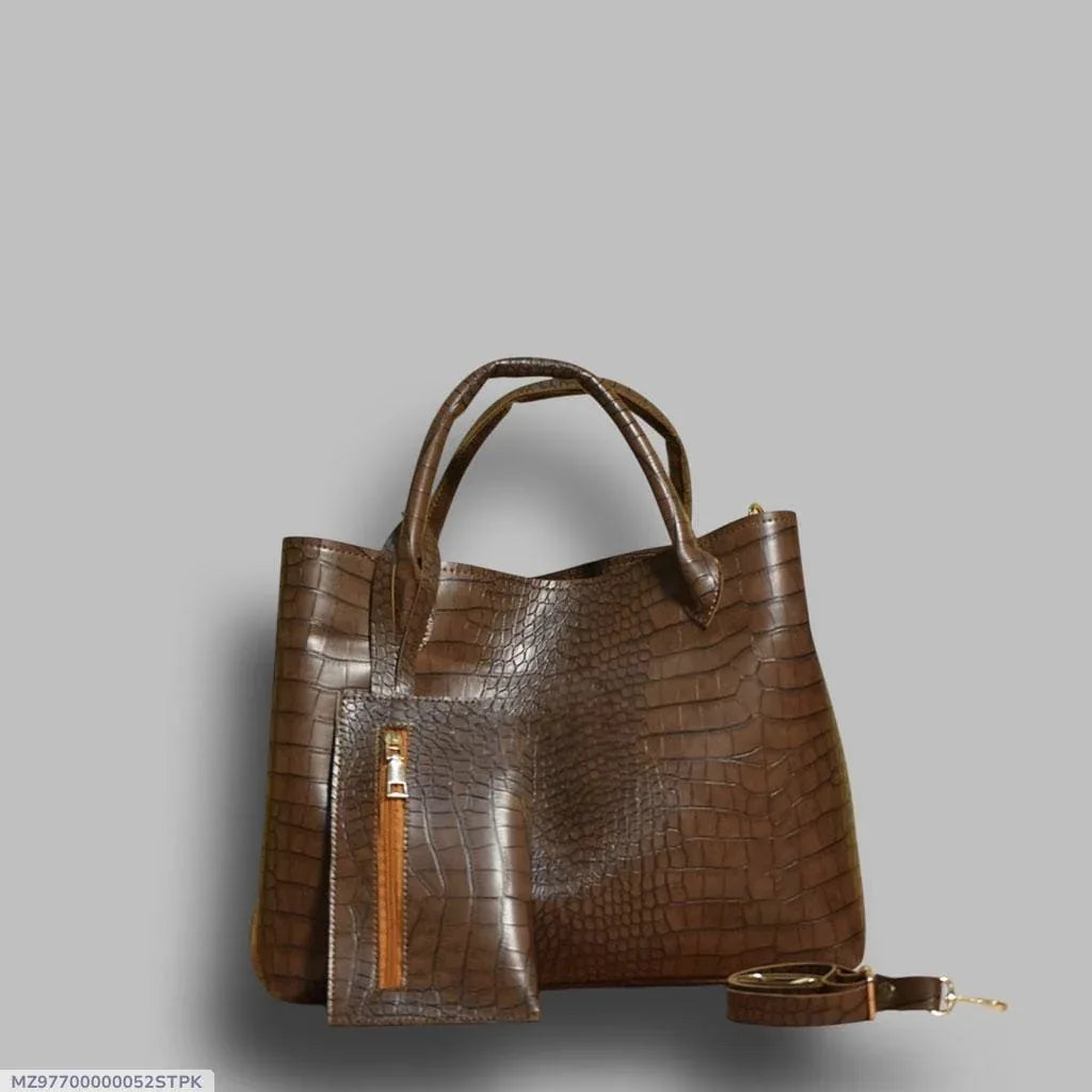 Brown crocodile-patterned handbag on a gray background