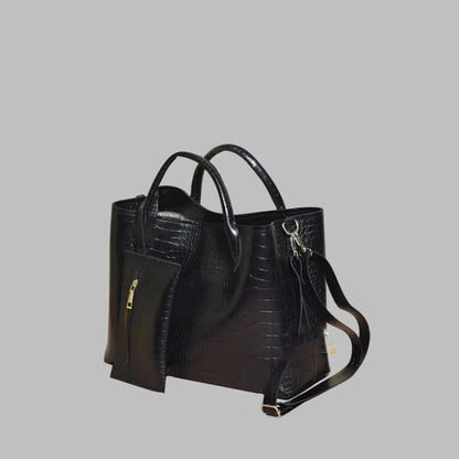 Black handbag with a textured pattern on a gray background