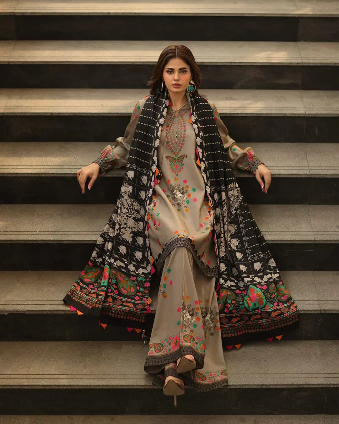 Woman in traditional embroidered outfit standing on steps