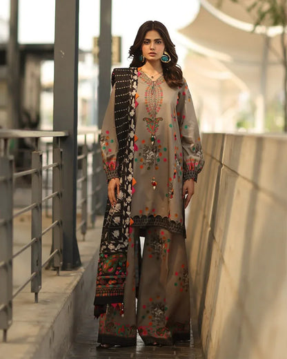 Woman in a traditional outfit with floral patterns standing outdoors.