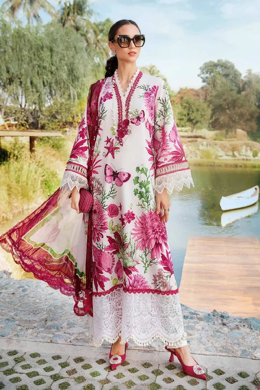 Woman in a floral dress standing by a lake with trees in the background