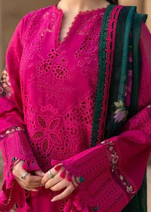 Close-up of a person wearing a bright pink embroidered traditional outfit with green accents.