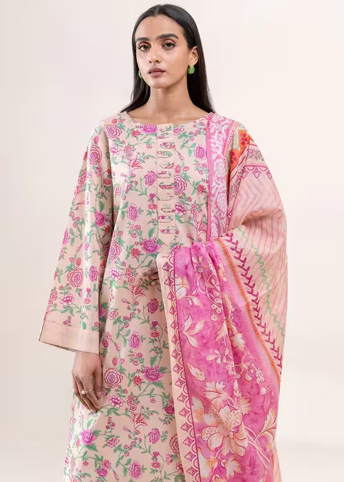 Woman wearing a floral dress with a pink dupatta on a white background