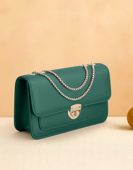 Green handbag with a chain strap on a beige background