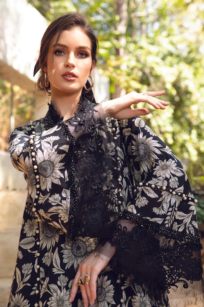 Woman wearing a black and white floral embroidered outfit with feather details outdoors.