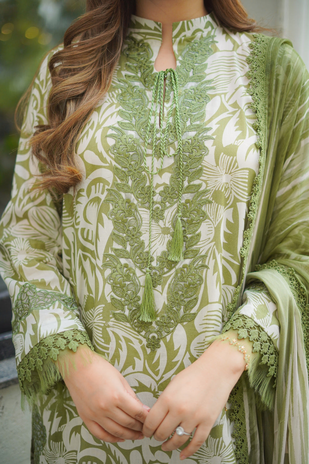Person wearing a green and white patterned kurta with a dupatta.